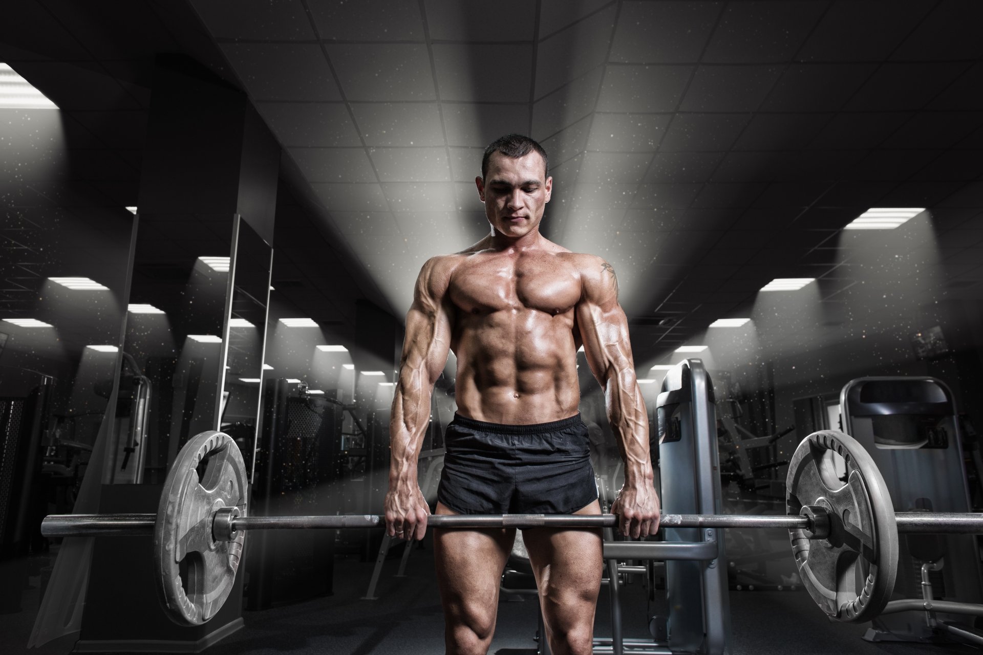 Athlete deadlifting a barbell in a dark gym